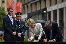 British Foreign Secretary Philip Hammond (R) and Australian Foreign Minister Julie Bishop sign a condolence book for victims of a siege at the Lindt Cafe where three people, including the lone gunman, died in December 2014