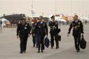 Military visitors walk during the sandstorm at the Dubai Airshow