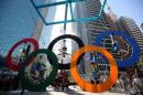 Acrobats perform on the Olympics rings at Paulista Avenue in Sao Paulo's financial center