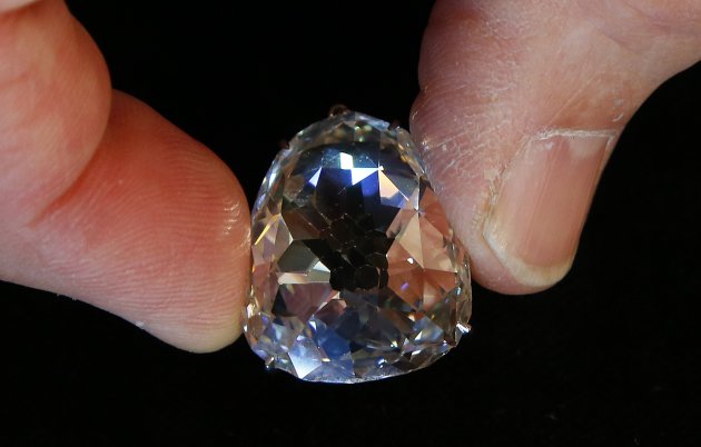 An employee holds a 400-year-old and 34.98 carats diamond known as