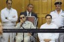 ALTERNATE CROP OF CAI103 -- Former Egyptian President Hosni Mubarak, seated, and his two sons, Gamal Mubarak, left, and Alaa Mubarak, right, attend a hearing in a courtroom at the Police Academy, Cairo, Egypt, Saturday, Sept. 14, 2013. Egypt's ousted long-time autocrat was back in court Saturday, grinning and waving for the resumption of his retrial on charges related to the killings of some 900 protesters during the 2011 uprising that led to his ouster. (AP Photo/Mohammed al-Law)