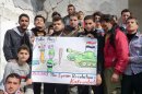 This citizen journalism image provided by Edlib News Network, ENN, which has been authenticated based on its contents and other AP reporting, shows anti-Syrian regime protesters holding a caricature placard during a demonstration, at Kafr Nabil town, in Idlib province, northern Syria, Friday, Feb. 15, 2013. Heavy fighting for control of the international airport in the northern Syrian city of Aleppo and a major military air base nearby has killed some 150 rebels and government soldiers over the past two days, activists said Friday. (AP Photo/Edlib News Network ENN)