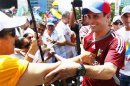 Opposition candidate Capriles greets a supporter on his way to register his presidential bid to the electoral authorities in Caracas