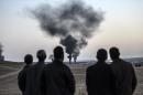 People watch as smokes rises from Kobane on October 26, 2014