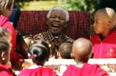 A file photo taken on July 24, 2007 shows former South African President Nelson Mandela joking with youngsters as they celebrate his 89th birthday at the Nelson Mandela Children's Fund in Johannesburg
