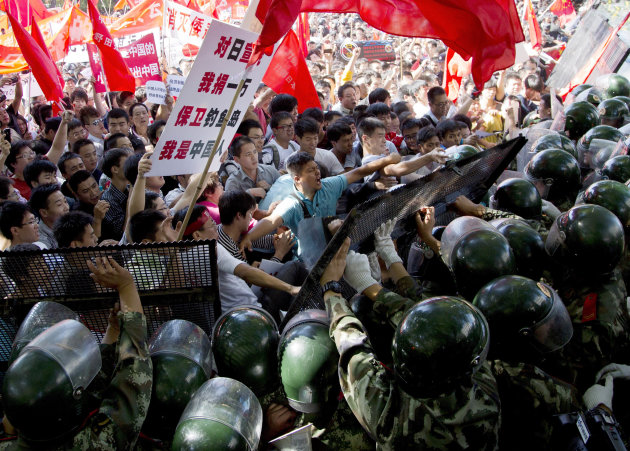 Chinese demonstrators clash with policemen at the barricades during an anti-Japan protests outside the Japanese Embassy in Beijing Saturday, Sept. 15, 2012. Angry protesters staged anti-Japanese demonstrations in cities across China Saturday over Japan's control of disputed islands, with a protest in Beijing turning violent before being brought under control by police. (AP Photo/Andy Wong)