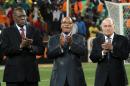 FILE - In this Feb. 10, 2013 file photo, Confederation of African Football (CAF) President Issa Hayatou, left, South African President Jacob Zuma, center, and FIFA President Sepp Blatter applaud ahead of the African Cup of Nations final soccer match between Burkina Faso and Nigeria at Soccer City Stadium in Johannesburg, South Africa. The son of a sultan from northern Cameroon, Issa Hayatou has ruled African soccer for 27 years and counting, a decade longer than Sepp Blatter has been in charge of FIFA. (AP Photo/Themba Hadebe,File)