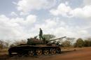 A Sudanese soldier stands atop a destroyed tank for the Sudanese Peoples Liberation Army (SPLA) of South Sudan in the oil region of Heglig on April 23, 2012