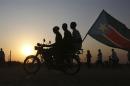 Men ride on a motorbike with South Sudan's national flag as they celebrate referendum results in Abyei