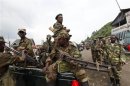 Congolese Revolution Army rebels sit in a truck as they patrol a street in Sake