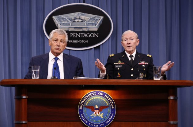 U.S. Defense Secretary Chuck Hagel (L) listens as Chairman of the Joint Chief of Staff General Martin Dempsey (R) speaks during a briefing on the Defense Department's FY2014 budget at the Pentagon in Washington April 10, 2013. The Pentagon unveiled a $526.6 billion budget on Wednesday that calls for base closures, program cancellations and smaller pay increases, but which is still $52 billion higher than spending caps set by law, putting the department on a path toward another year of financial uncertainty. 
REUTERS/Kevin Lamarque  (UNITED STATES - Tags: POLITICS BUSINESS MILITARY)