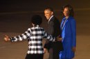 U.S. President Barack Obama, middle, and first lady Michelle Obama, right, react as Maite Nkoana-Mashabane, Minister of International Relations and Cooperation, left, gestures during their arrival at Waterkloof Airbase in Pretoria, Friday, June 28, 2013. President Obama is receiving the embrace you might expect for a long-lost son on his return to his father's home continent, even as he has yet to leave a lasting policy legacy for Africa on the scale of his two predecessors. (AP Photo/Themba Hadebe)