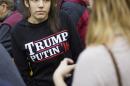 FILE - In this Sunday, Feb. 7, 2016 file photo, a woman wears a shirt reading 'Trump Putin '16' while waiting for Republican presidential candidate Donald Trump to speak at a campaign event at Plymouth State University in Plymouth, N.H. Donald Trump just keeps giving Russian President Vladimir Putin more reasons to hope he wins the U.S. election, while raising serious questions about the Republican candidate's intentions toward the Kremlin. ﻿In his most recent outreach to Putin, Trump not only refused to condemn Russia's military takeover of Ukraine's Crimean Peninsula but said, if elected, he would consider recognizing it as Russian territory and lifting sanctions against Moscow. 