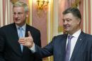 Ukrainian President Petro Poroshenko, right, greets Swedish Foreign Minister Carl Bildt during their meeting in Kiev, Ukraine, Tuesday, July 1, 2014. Ukrainian forces and pro-Russian separatists fought with heavy weapons in the country's east Tuesday, and the rebels captured the Interior Ministry headquarters in a major city after an hours-long gun battle, a day after the president said rebels weren't serious about peace talks and ended a cease-fire. (AP Photo/Presidential Press Service, Mykhailo Markiv, Pool)