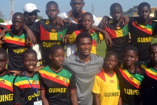 La star camerounaise Samuel Eto'o pose avec des enfants dans une école de football à Conakry en Guinée, le 23 février 2013