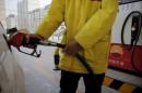 A gas station attendant puts fuel into a customer's car at PetroChina's filling station in Beijing