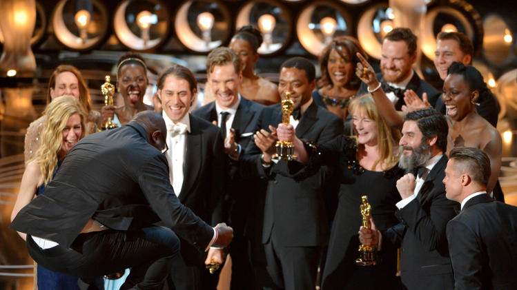 Director Steve McQueen, left, celebrates with the cast and crew of "12 Years a Slave" as they accept the award for best picture during the Oscars at the Dolby Theatre on Sunday, March 2, 2014, in Los Angeles. (Photo by John Shearer/Invision/AP)