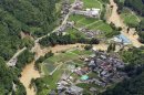 A road, left, is buried in a landslide in Yame, Fukuoka Prefecture, Japan, Sunday, July 15, 2012. Heavy rain triggered flash floods and mudslides in southern Japan this week, killing over two dozens of people. (AP Photo/Kyodo News) JAPAN OUT, MANDATORY CREDIT, NO LICENSING IN JAPAN, CHINA, HONG KONG, SOUTH KOREA AND FRANCE