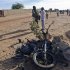 A soldier points his finger at the wreckage of a motorbike used by a suicide bomber who blew himself up at a checkpoint north of Gao
