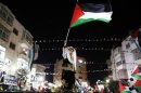 A Palestinian boy in traditional clothes waves a Palestinain flag during a rally in the West Bank city of Ramallah