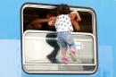 A migrant carries a child in a train at the station in Beli Manastir