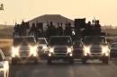 An image grab taken from a video released by Islamic State group's official Al-Raqqa site via YouTube on September 23, 2014, allegedly shows Islamic State (IS) group recruits riding in armed trucks in an unknown location
