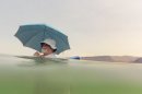 Mike Bouse of Henderson, Nev., shades himself with an umbrella as he floats in the waters along Boulder Beach at Lake Mead, Saturday, June 29, 2013 near Boulder City, Nev. Bouse and his wife planned to spend most of the day in and out of the water to escape the heat in the Las Vegas area where Saturday's daytime high was expected to reach 117 degrees, the city's all-time high. It was 108 at noon Saturday in Sin City. (AP Photo/Julie Jacobson)