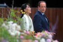 FILE - In this July 26, 2012 file photo, Myanmar opposition leader Aung San Suu Kyi, left, and French President Francois Hollande walk in the Elysee Palace garden in Paris. The Myanmar opposition leader's triumphant two-week tour of Europe, her first return in 24 years, triggered an outpouring of nostalgia that put a softer, more personable face on the woman known for her steely defiance and stoicism. (AP Photo/Bertrand Langlois, Pool, File)