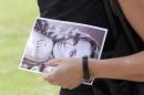 A mourner leaves, holding a picture of model Reeva   Steenkamp, after her memorial service at the Victoria Park Crematorium in Port   Elizabeth February 19, 2013. REUTERS/Rogan Ward/Files