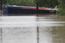 A San Antonio metro bus sits in floodwaters after it was swept off the road during heavy rains, Saturday, May 25, 2013, in San Antonio. (AP Photo/Eric Gay)