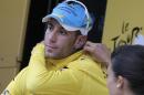 Italy's Vincenzo Nibali, puts on the overall leader's yellow jersey on the podium of the sixth stage of the Tour de France cycling race over 194 kilometers (120.5 miles) with start in Arras and finish in Reims, France, Thursday, July 10, 2014. (AP Photo/Christophe Ena)