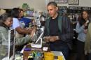 U.S. President Barack Obama pays for purchases at Pleasant Pops, as daughters Malia and Sasha enjoy a popsicle, in Washington