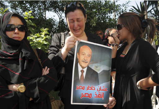 Women mourn at the funeral for Egypt's former spy chief, Omar Suleiman, seen in the poster at center, in Cairo, Egypt, Saturday, July 21, 2012. Egypt’s top military commander and mourners attended a military funeral honoring Egypt’s former spy chief Omar Suleiman, who died in a U.S. hospital at the age of 76. The Arabic on Suleiman's presidential campaign poster reads, 