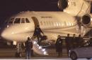 An unidentified man leaves a Dassault Falcon jet of Swiss air force at the airport in Geneva, Switzerland, Sunday, Jan 17, 2016. A US government plane waited nearby to bring back to the US the men who were left from imprisonment in Iran the day before. (AP Photo/Laurent Cipriani)