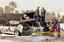 Residents gather at the site of a car bomb attack in the Ameen district in Baghdad
