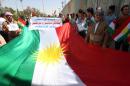 Iraqi Kurdish protesters deploy a giant flag of their autonomous Kurdistan region during a pro-independence rally outside the Kurdistan parliament building in Arbil, on July 3, 2014
