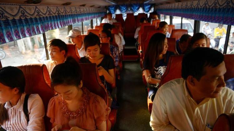 Commuters travel on a public bus in Phnom Penh on February 7, 2014