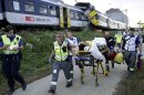 Swiss rescue workers wheel a wounded person on a stretcher after two regional trains crashed head on near Granges-Pres-Marnand near Payerne