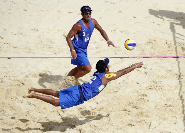 Venezuela's Jesus Villafane Marquina tries to save a point as teammate Igor Hernandez Colina looks on during their men's beach volleyball preliminary round match against the Netherlands at the London 
