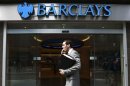 A man walks past a branch of Barclays Bank in the City of London