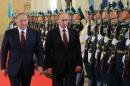 Kazakh President Nursultan Nazarbayev (L) and Russian President Vladimir Putin review an honor guard during a ceremony in Astana, on October 15, 2015