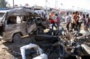 Residents gather at the site of a car bomb attack on April 25 in Baghdad that killed at least eight and wounded 23 others.
