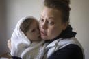 Viktoria holds her daughter Stephanya at a clinic which specialises in children's neurological disorders in Donetsk