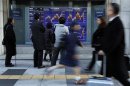 People look at a stock index board outside a brokerage in Tokyo
