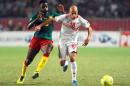 Tunisian defender Yassine Mikeri vies for the ball with Cameroon's forward Bilong Song (L) during the FIFA World Cup qualification match between Tunisia and Cameroon on October 13, 2013 in Rades Olympic Stadium in Tunis