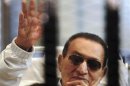 File picture shows former Egyptian President Mubarak waving inside a cage in a courtroom at the police academy in Cairo
