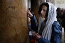 A Catholic pilgrim touches a column inside the Church of the Nativity, traditionally believed by Christians to be the birthplace of Jesus Christ, in the West Bank town of Bethlehem, Monday, Dec. 24, 2012. Thousands of Christian worshippers and tourists arrived in Bethlehem on Monday to mark Christmas at the site many believe Jesus Christ was born. (AP Photo/Adel Hana)