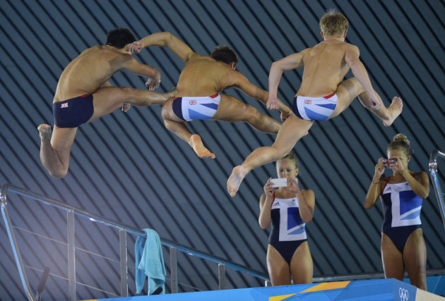 British divers Couch and Barrow take photographs of Daley and diving teammates from the 10 metre board at the Aquatics Centre in the Olympic Park in Stratford in east London