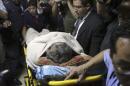 Former Guatemalan dictator Rios Montt lies on a stretcher and is covered with a blanket as he enters the Supreme Court of Justice for his hearing in Guatemala City