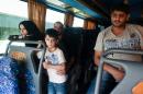 Refugees fleeing the war in Syria sit on a bus as they are driven to the Kokkinotrimithia refugee camp, West of Nicosia in Cyprus, on September 6, 2015